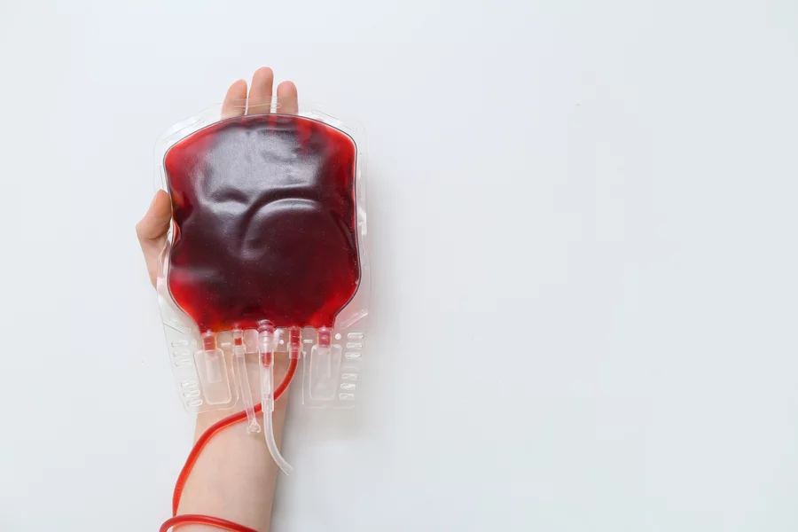 A woman’s hand holding a blood bag.